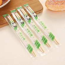 Macro shot of 4 pairs of natural bamboo chopsticks in individual panda packaging