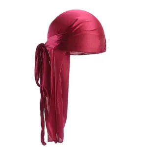 Detailed close-up of wine red silky durag with premium satin texture and long straps