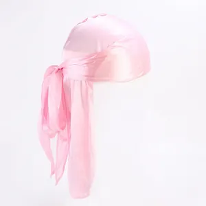 Detailed close-up of pink silky durag featuring long tail straps and premium glossy finish