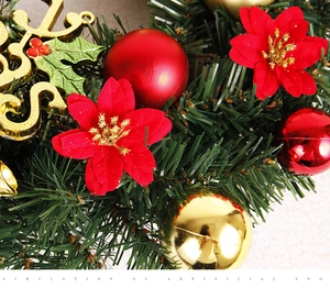 Close-up of artificial Christmas flower wreath with red poinsettia and gold ornaments