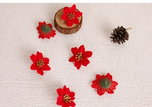 Close-up of red artificial poinsettia flower heads with gold glitter for Christmas decor