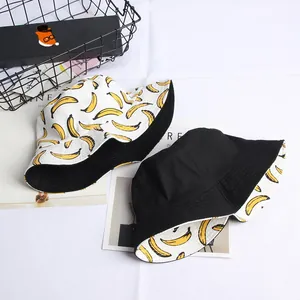 Detail of reversible canvas bucket hat showing yellow banana prints and black lining fabric