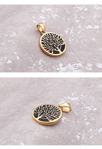 Detailed view of round golden stainless steel pendant with black Tree of Life pattern