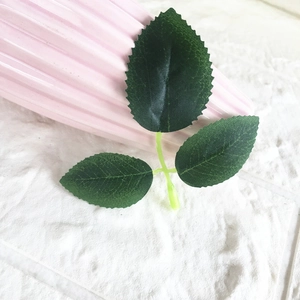 Close-up of artificial rose leaves with realistic serrated edges and green leaf veins
