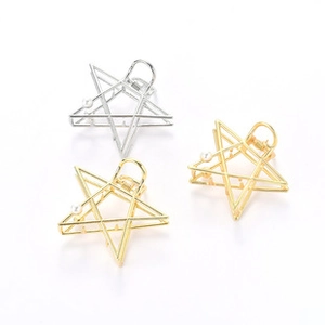 Detail of star-shaped metal hair claws with pearl accents in gold and silver finish