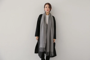 Detail of grey cashmere scarf with soft brushed texture and neat tassel edges