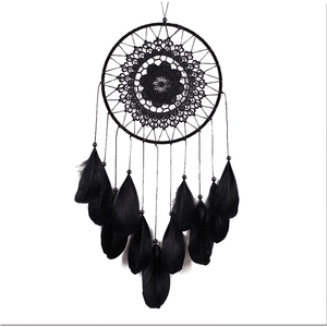 Handmade black dream catcher with woven floral pattern and goose feathers on white background
