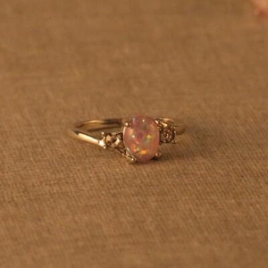Makroaufnahme eines Rings mit ovalem rosa Opal, Diamanten und Roségold-Beschichtung