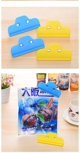 Close-up of cloud-shaped food bag sealing clips in blue and yellow colors on a snack bag