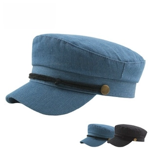 Detail of nautical flat top cap with metallic chain, buttons and denim fabric texture