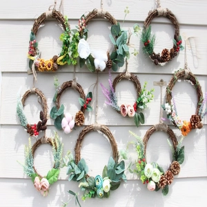 Collection of handmade Christmas wreaths with berries and flowers on white wood