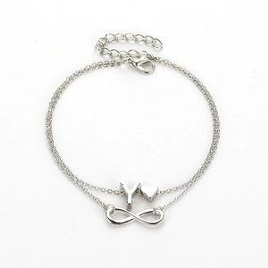 Detail of silver double-layer anklet with infinity, heart, and letter Y pendants