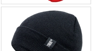 Close-up of black TRUE® woven label on high-quality knit texture of the beanie hat
