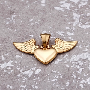 Golden heart necklace with detailed angel wings pendant on a textured grey background