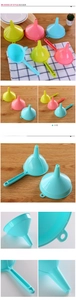 Close-up of colorful plastic kitchen funnels with long handles and hanging holes