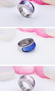 Wide stainless steel rings with faceted blue, purple, and pink crystal stones