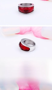 Macro shot of large faceted red crystal stone set in a polished stainless steel ring