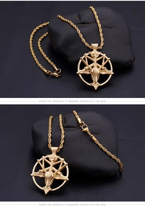 Macro detail of golden Baphomet goat head pendant on rope chain with black leather background