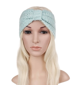 Detail of light green chunky knit headband with twist knot design for winter warmth