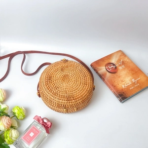 Detailed view of handwoven round rattan bag with premium brown leather strap