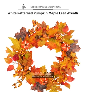 Detail of autumn wreath with maple leaves, small white pumpkins, and vibrant red berries