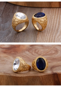 Détail macro d'une bague vintage dorée avec pierre bleue ovale et gravures baroques
