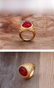 Détail d'une bague pour homme plaquée or avec rubis rouge et gravures florales