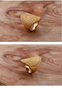 Macro view of vintage gold ring with fan-shaped dotted texture on wood surface