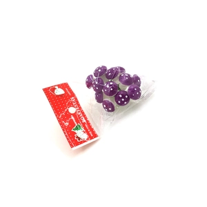 Macro detail of 12 purple polka dot mushroom figurines for festive DIY plant decoration