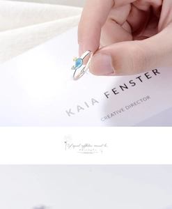 Close-up of cute whale ring with blue enamel detail on finger with aesthetic backdrop