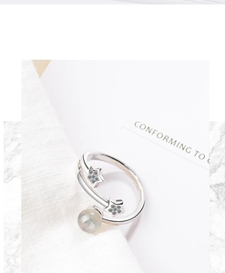 Detail of silver star ring with transparent crystal bead on a minimalist white backdrop
