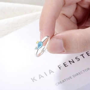 Minimalist silver open ring with blue whale charm design shown on hand for women
