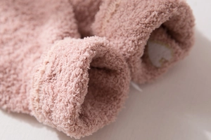 Close-up of soft pink coral fleece socks with embroidered heart showing plush texture
