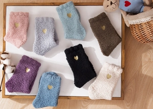 Detailed flat lay of coral fleece socks in eight colors featuring heart embroidery