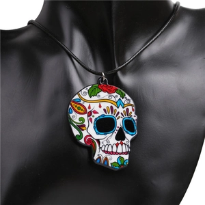 Close-up of a colorful sugar skull pendant on black wax cord on a model neck