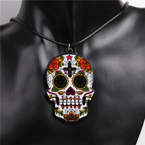 Close-up of Day of the Dead skull and rose acrylic pendant on a black cord necklace