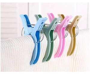 Close-up of colorful heavy-duty plastic windproof pegs on thick white knitted fabric