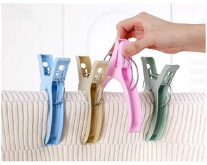 Detail of large windproof laundry clips with reinforced springs on thick white knit fabric