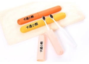 Close-up of portable travel toothbrush cases in candy colors on a soft towel background