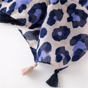 Detailed view of leopard print scarf with woven linen texture and decorative fringe trim