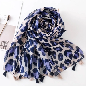 Leopard print cotton linen scarf with tassels displayed on a minimalist magazine
