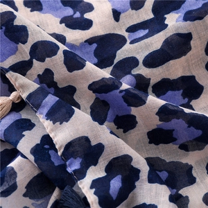 Close-up of blue leopard print cotton linen scarf with soft fringe and woven texture