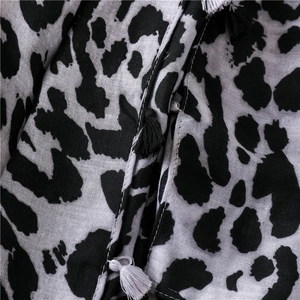Detail of classic leopard print scarf featuring black and white decorative tassels