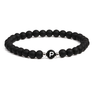 Detail of 6mm matte black stone beads bracelet with a white letter P charm and silver spacers