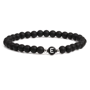 Black matte stone bracelet featuring a silver letter E bead and metallic accents