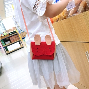 Detail of red rabbit crossbody bag with cute ear design shown on a child model