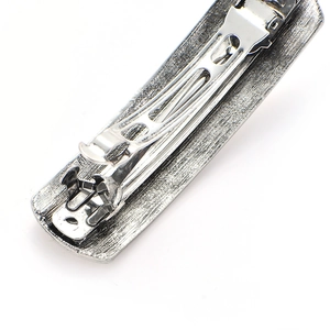 Detailed macro view showing the sturdy silver metal spring clip back of the hair accessory