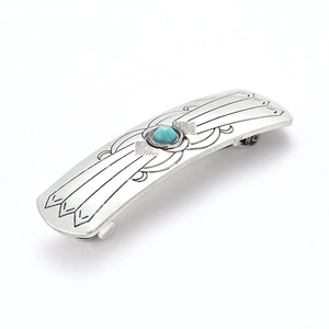 Vintage silver hair clip with blue turquoise stone and floral engraving on white background