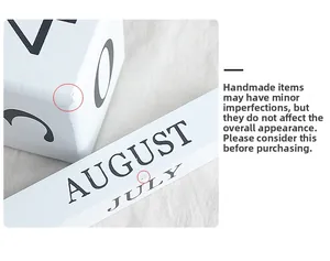 Close-up of white wooden perpetual calendar showing texture and handmade craftsmanship details