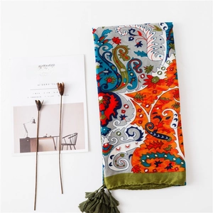 Détail du châle ethnique imprimé paisley avec pompons verts et texture en coton et lin